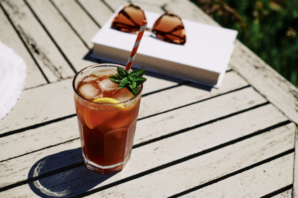 Iced Tea with Lemon and mint on a garden table in bright sunshine.