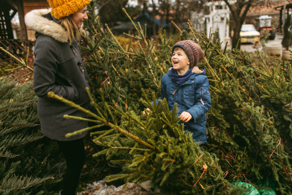 Mother and son choosing Christmas tree in a plant nursery