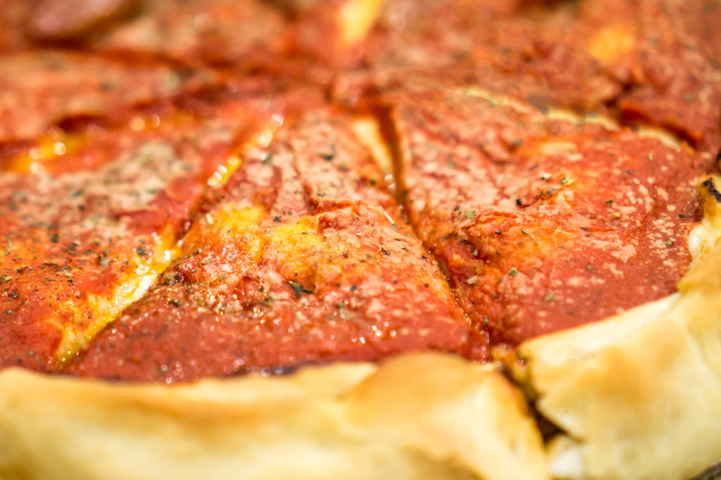 Deep dish pizza closeup photo.