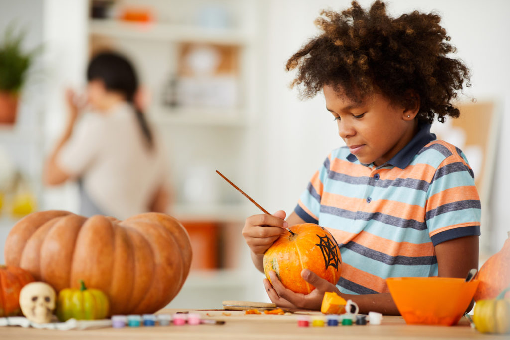Child making a design on a pumpkin